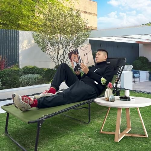 Man reading a magazine on a lounge chair in a garden.