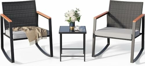 Two modern rocking chairs with cushions and a small table with flowers.