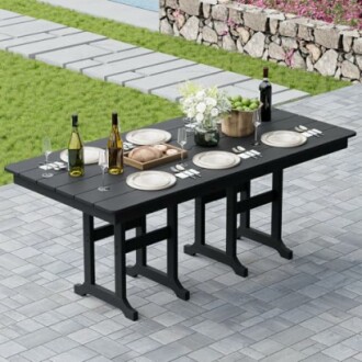 Outdoor dining table with plates, glasses, and wine bottles on a patio.