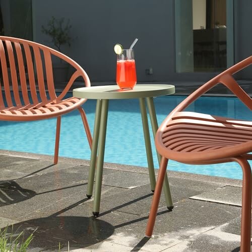 Modern patio chairs and a table with a drink by the pool.