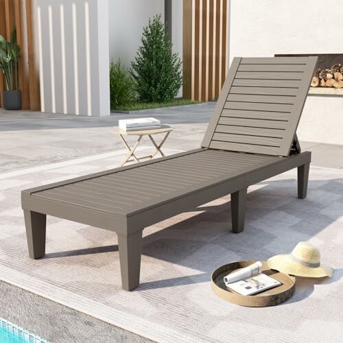 Outdoor lounge chair near pool with hat and magazine