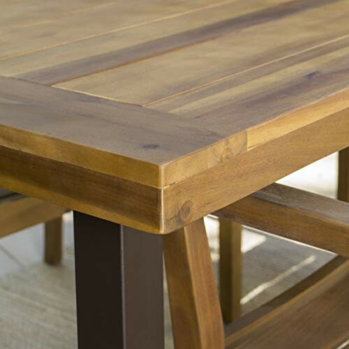 Close-up of a wooden dining table corner with sturdy legs.